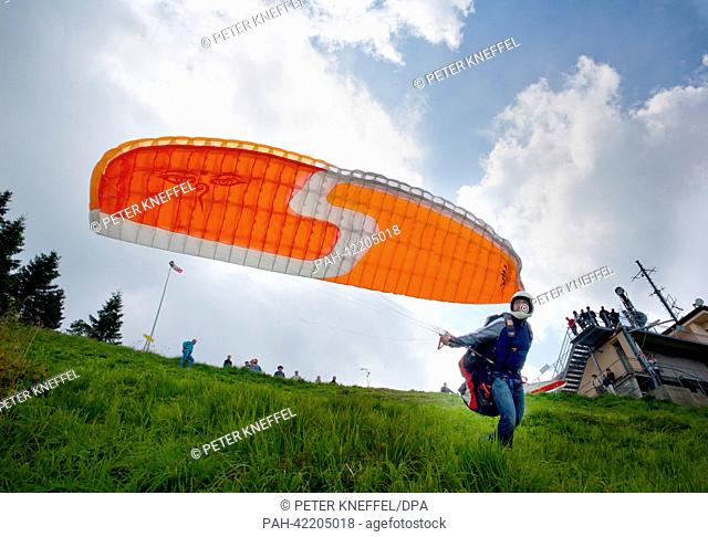 A paraglider runs to take off from the Laberberg mountain near Oberammergau, Germany, 31 August 2013. Photo: Peter Kneffel | usage worldwide