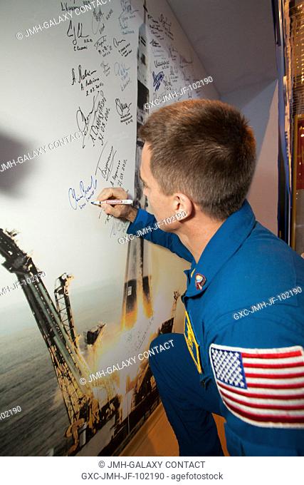 Inside the Gagarin Museum at the Baikonur Cosmodrome in Kazakhstan, Expedition 3536 Flight Engineer Chris Cassidy of NASA conducts a traditional signing March...