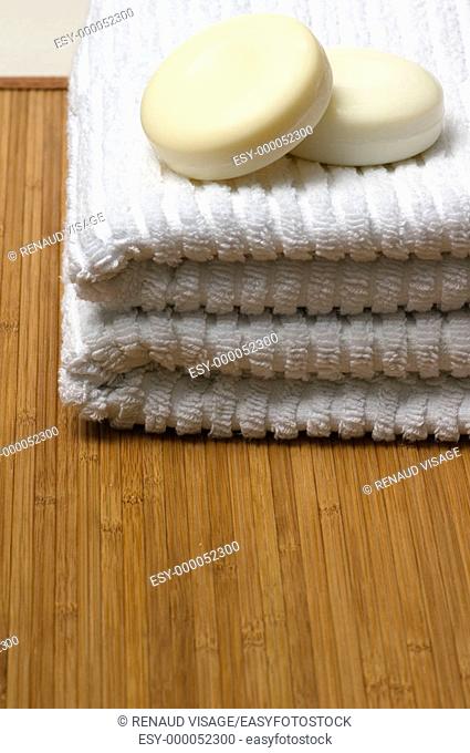 Soap and white towels on bamboo mat