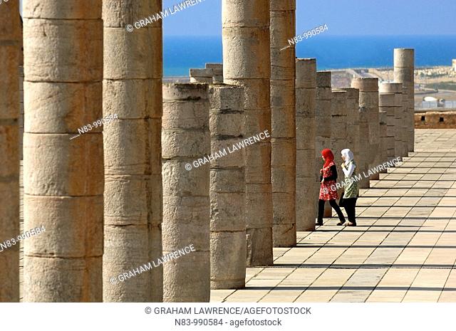 Two Muslim women walks between the pillars of the uncompleted Hassan Mosque, Rabat, Morocco, Africa