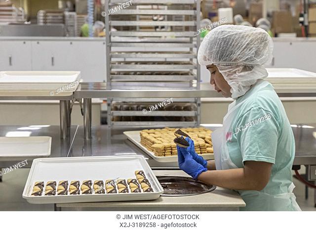 Hilo, Hawaii - Workers make Macadamia Nut Shortbread dipped in milk chocolate at Big Island Candies