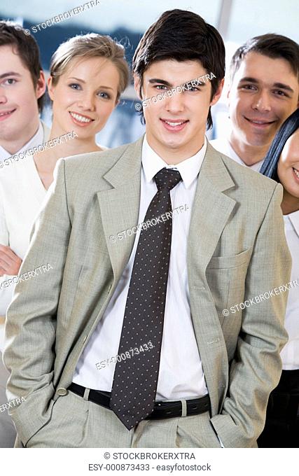 Portrait of smart businessman standing in front of his workteam