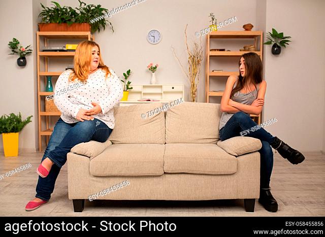 Two female women sinning on sofa edges at dietitian office. Weighing loss concept