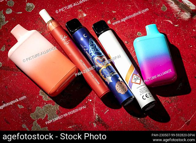 05 May 2023, Lower Saxony, Hanover: Several disposable e-cigarettes lie on a table. On the outside, they resemble colored markers and come in fruity flavors