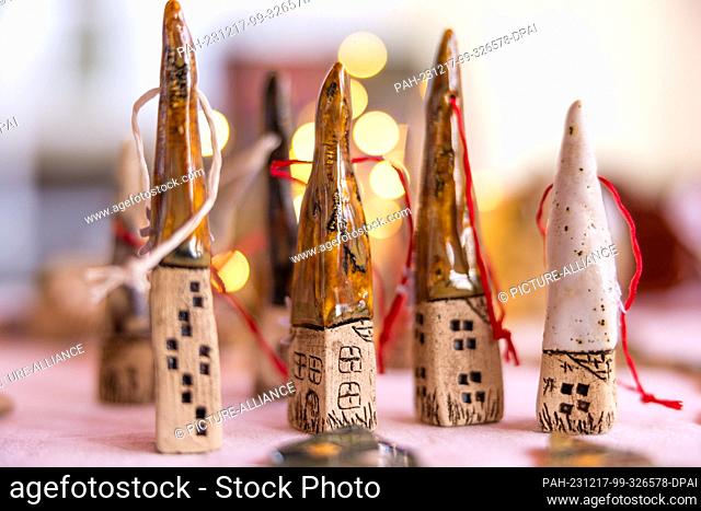 16 December 2023, Brandenburg, Leuthen: Decorative clay objects are on display at a stall at a small Advent market. Advent and Christmas markets are also held...