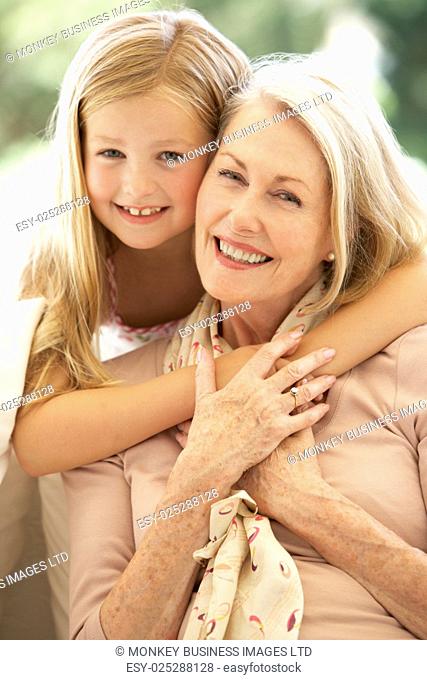 Grandmother With Granddaughter Laughing Together On Sofa