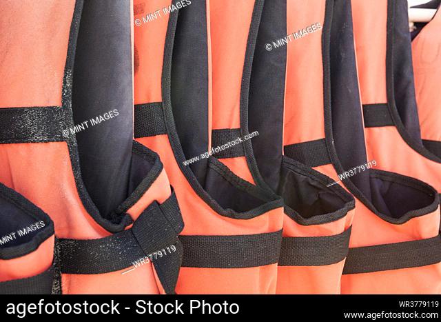 Close-up of orange life jackets in a row