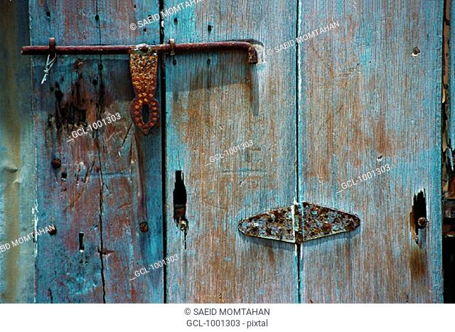 Old wooden door with rusty bolt