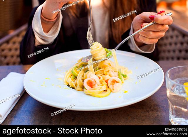 Close up of fettuccini on the spoon, pasta with shrimps and beans
