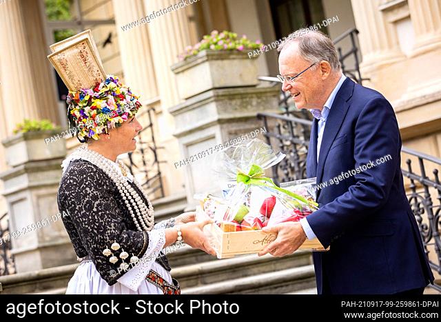 17 September 2021, Lower Saxony, Hanover: Marina Tajger, Altländer Flower Queen, presents Stephan Weil (SPD), Minister President of Lower Saxony