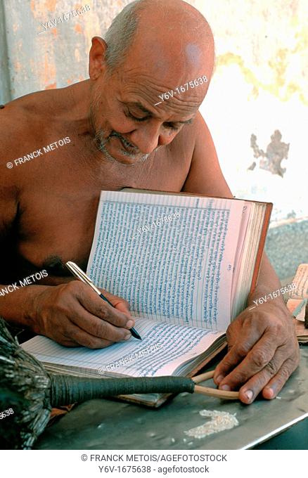 Jaïn monk writing his teachings. At Shri Mahaveerji, Rajasthan, India. He belongs to the digambar sect, a jaïn group whose monks live naked to show off their...