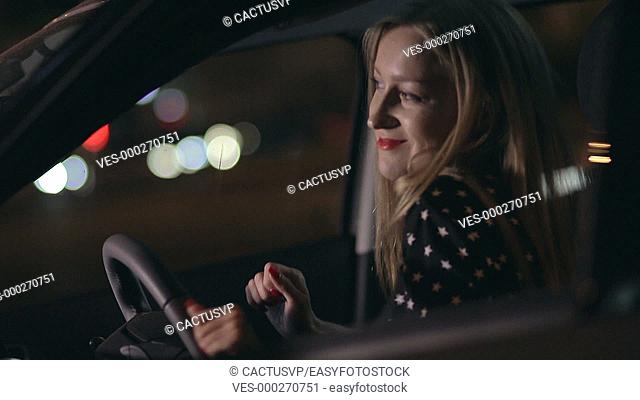Woman in car having fun at night dancing