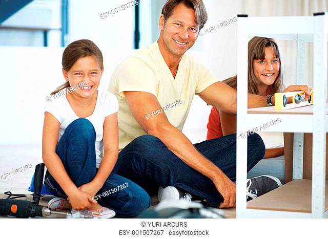 Portrait of smiling family taking a break from building a shelf