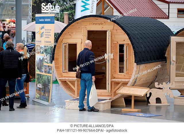 21 November 2018, Saxony, Leipzig: A visitor to the ""Touristik & Caravaning"" trade fair stands in front of a Scandinavian camping barrel