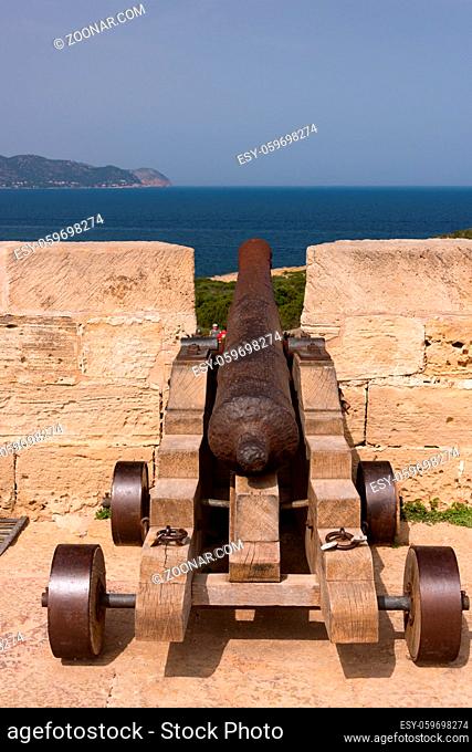 Old antique iron cannon on the old defence tower of Punta de N'Amer near Sa Coma, on the Spanish Balearic Mediterranean island of Mallorca