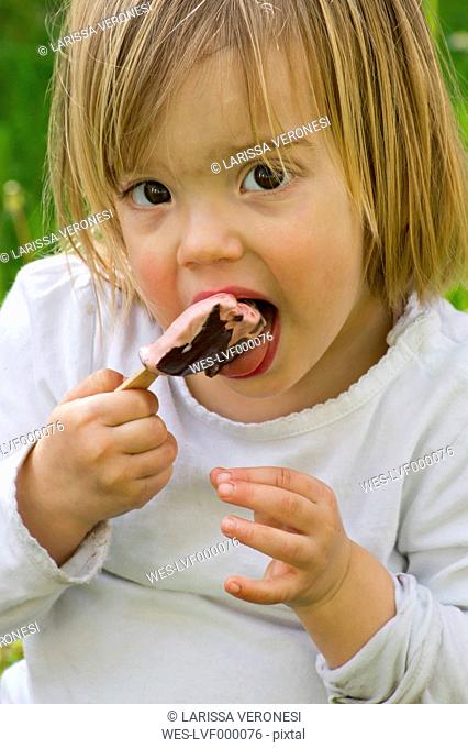 Germany, Girl eating popsicle ice cream, close up