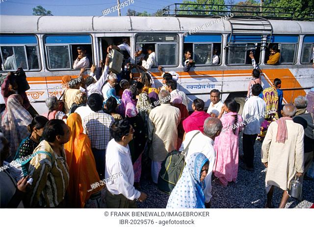 People trying to enter an already overloaded public bus in Bhuj, Gujarat, India, Asia