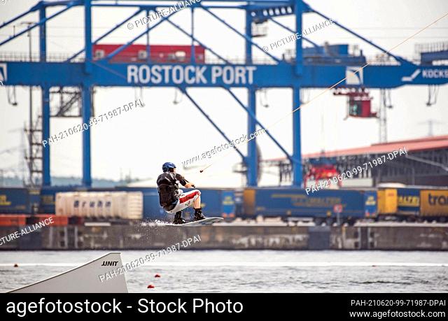 20 June 2021, Mecklenburg-Western Pomerania, Rostock: A wakeboarder jumps on the Warnow river at the IGA Park Rostock. The 6-mast wakeboard facility from the...