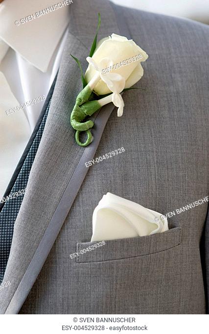 Groom in grey suit wearing a boutonniere