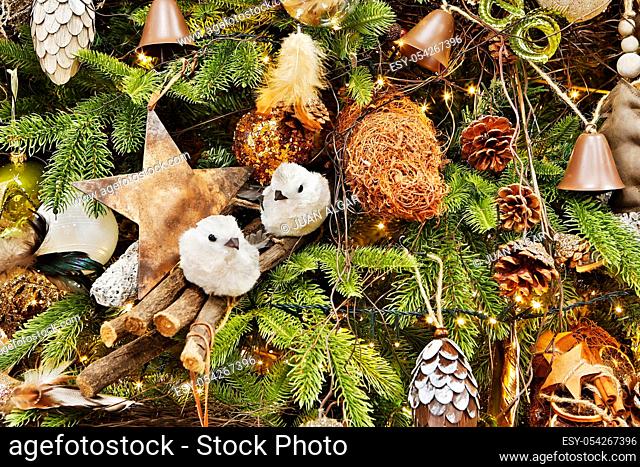 Background of fir tree branches with various cozy rustic decor and golden burning garland