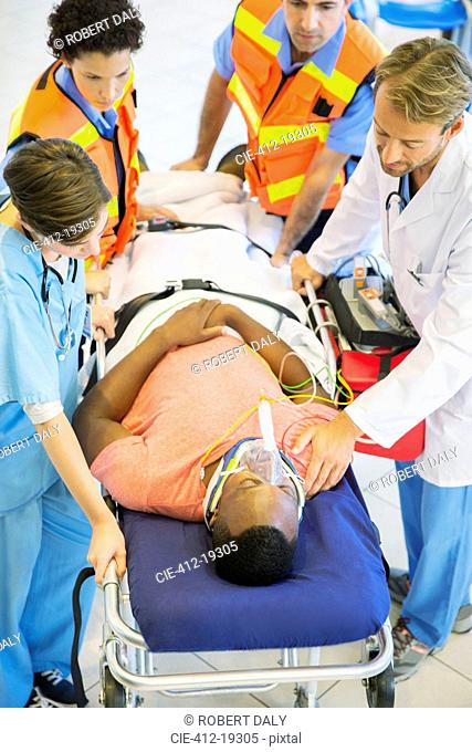 Doctor, nurse and paramedics examining man on stretcher