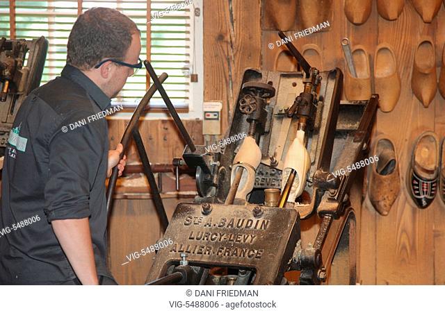Craftsman using a machine to make traditional Dutch wooden shoes in the small town of Zaanse Schans, Holland, Netherlands, Europe