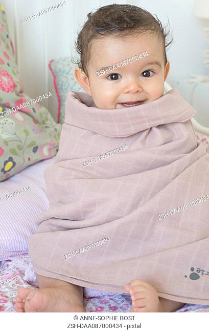Baby wrapped in a towel after a bath, portrait