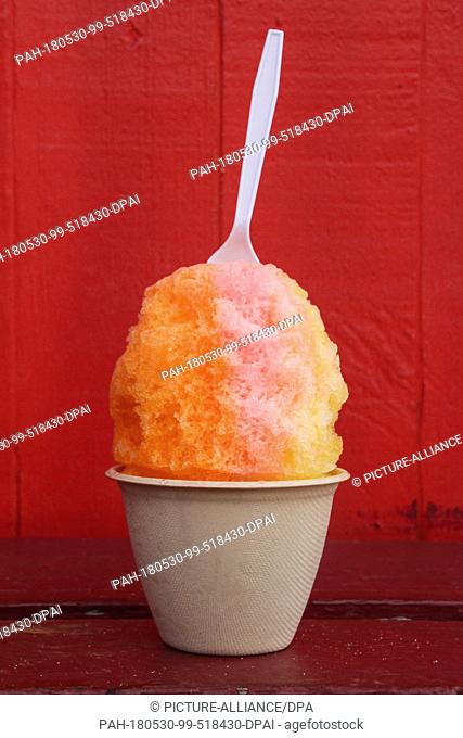 08 May 2018, US, Hawaii, Hilo: A cup of Shave Ice stands on a table in front of the ice cream parlor of JoJo's Shave Ice