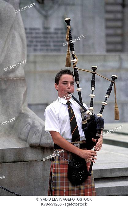 Scotland, Glasgow. Kid playing a traditional bagpipe at Glasgow’s Town hall, George Square