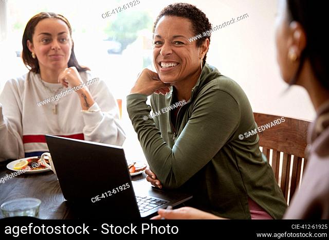 Happy mother and daughters at laptop