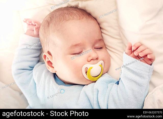 Cute three month old baby sleeping in comfortable bed. Concept of the family andparenting