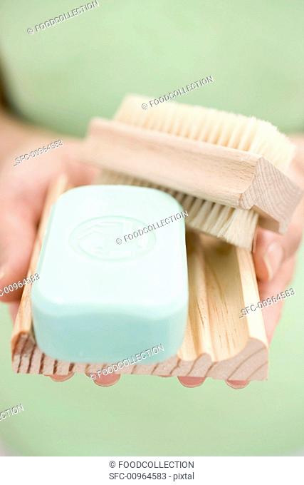 Woman holding soap, soap dish and brush