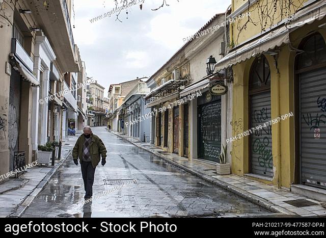 17 February 2021, Greece, Athen: A man walks past closed shops in the Plaka district. A strict lockdown has been in effect for the greater Athens area for a...
