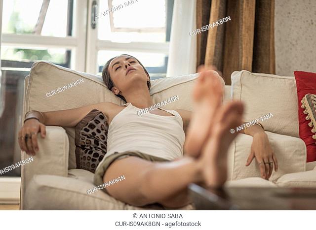 Young woman sleeping on sitting room sofa