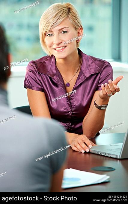 Smiling business people talking on business meeting. Over the shoulder view