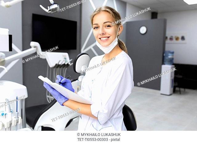 Dental assistant writing notes
