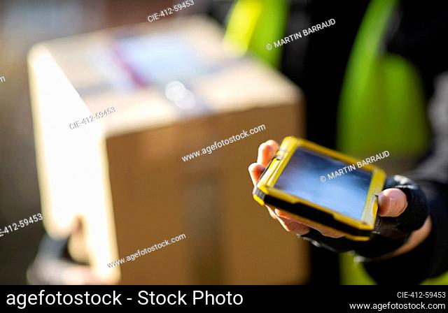 Close up courier with smart phone delivering package