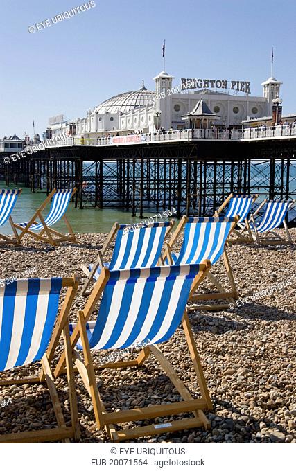 Brighton Pier with empty deckchairs on the beach in the foreground