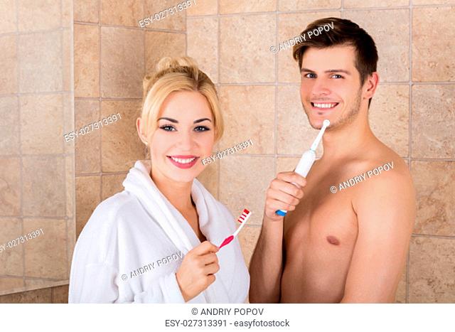 Portrait Of Young Smiling Couple With Brushing Teeth In Bathroom