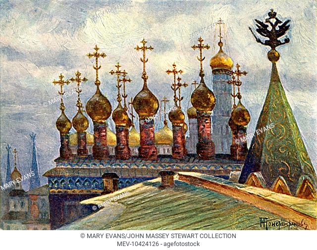An array of golden onion domes viewed from the watchtower of the Terem Palace in the Kremlin complex, Moscow, Russia. A two-headed eagle