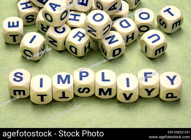 simplify reminder, pragmatic, declutter or get organized concept, - letter dices on a handmade paper