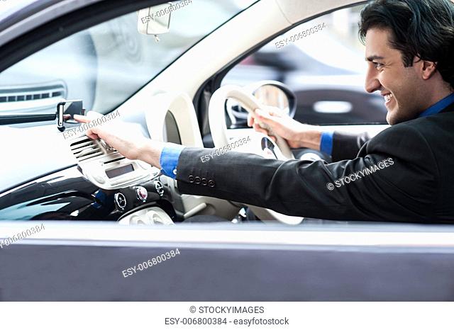 Smiling male executive operating gps device while driving