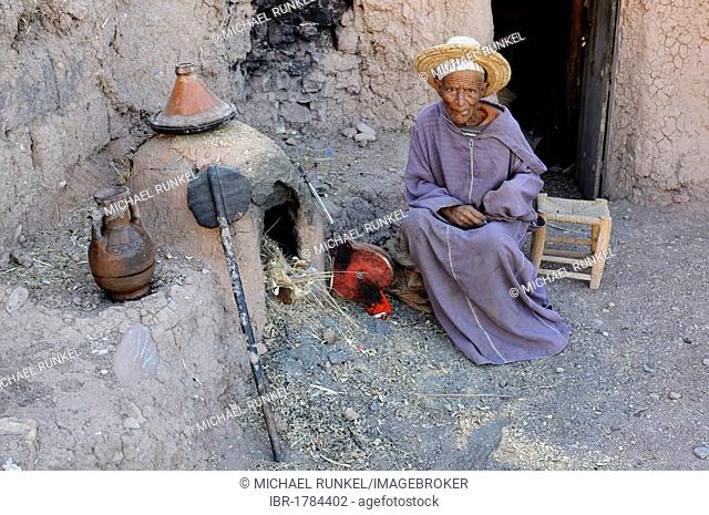 Old man traditionally baking bread in his clay oven, Ait Benhaddou, Morocco, Africa