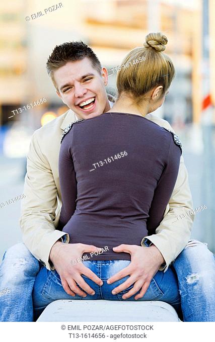 Intimate touch happy young couple on a bench