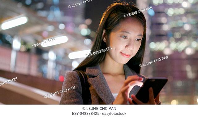 Business woman read on smart phone at night