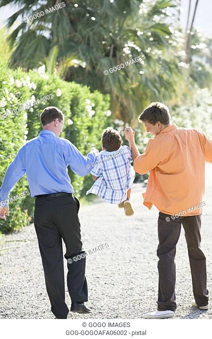 Gay couple walking with their son