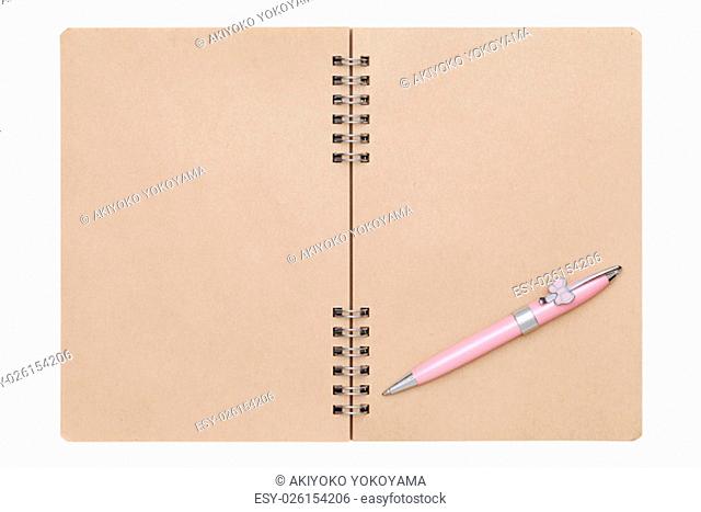 blank spiral brown notebook with ball point pen isolated on white background