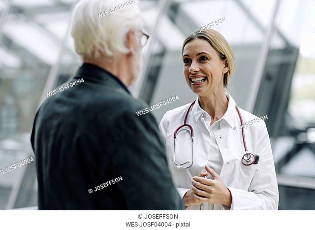 Smiling female doctor talking to senior man