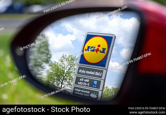 ILLUSTRATION - 15 May 2023, Saxony, Leipzig: A stele with the logo of the discounter Lidl can be seen in the rearview mirror of a passenger car
