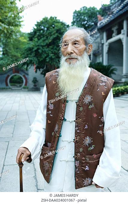 Elderly man wearing traditional Chinese clothing, using cane, portrait